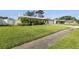 Attractive home featuring lush green lawn, a driveway, and is complemented by mature trees at 13000 90Th Ave, Seminole, FL 33776