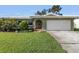 Charming single-story home with an attached two-car garage, and a lush green lawn at 13000 90Th Ave, Seminole, FL 33776