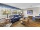 Bright living room boasts hardwood floors, a comfortable couch, and a large window with great views at 13000 90Th Ave, Seminole, FL 33776