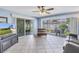 Bright living room with tile flooring, ceiling fan, and sliding glass doors to a screened patio at 13000 90Th Ave, Seminole, FL 33776