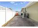 Property side yard featuring a white fence and concrete pad at 13000 90Th Ave, Seminole, FL 33776