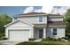 Charming two-story home with attached two car garage, neatly manicured lawn, and welcoming entryway at 13576 Tropical Breeze Way, Hudson, FL 34669