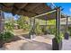 Brick patio and landscaped backyard is showcased with a canvas pergola, mature trees, and greenery at 1402 E Mohawk Ave, Tampa, FL 33604