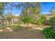 Green backyard with mature trees, a wooden fence, and established landscaping at 1402 E Mohawk Ave, Tampa, FL 33604