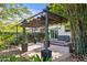 Charming backyard showcasing a brick patio, canvas pergola, lush bamboo, and landscaped surroundings at 1402 E Mohawk Ave, Tampa, FL 33604