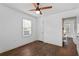 Bedroom with ceiling fan, hardwood floors, and access to an ensuite bathroom at 1402 E Mohawk Ave, Tampa, FL 33604