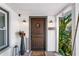Inviting entryway featuring a rustic wooden door with stylish outdoor decor at 1402 E Mohawk Ave, Tampa, FL 33604