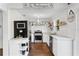 Well-lit kitchen featuring white cabinetry, stainless steel appliances, and decorative tile backsplash at 1402 E Mohawk Ave, Tampa, FL 33604