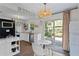 Charming eat-in kitchen with white cabinets, stainless steel appliances, and access to the backyard at 1402 E Mohawk Ave, Tampa, FL 33604
