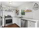 Bright kitchen with white cabinets, stainless steel appliances, and decorative tile backsplash at 1402 E Mohawk Ave, Tampa, FL 33604