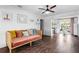 Cozy living room with a unique daybed, wood-look tile flooring, and an open layout to the kitchen and backyard at 1402 E Mohawk Ave, Tampa, FL 33604