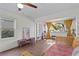 Bright living room featuring wood-look tile floors, rattan sofa, built-in shelving, and lots of natural light at 1402 E Mohawk Ave, Tampa, FL 33604