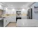 Modern kitchen featuring white cabinets, stainless steel appliances, and a marble countertop island at 17920 Gulf Blvd # 1901, Redington Shores, FL 33708