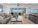 Cozy living room with comfortable seating, ceiling fan, TV and sliding glass doors with water views at 17920 Gulf Blvd # 1901, Redington Shores, FL 33708