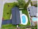 An aerial view highlights a home with a private pool, fully fenced yard, and mature trees at 1873 Murray Ave, Clearwater, FL 33755