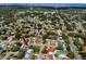 Wide aerial view of a neighborhood with mature trees featuring a home with a swimming pool and well-maintained lawn at 1873 Murray Ave, Clearwater, FL 33755