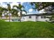 A backyard features a pool with an expansive deck, mature landscaping, and a fully fenced perimeter at 1873 Murray Ave, Clearwater, FL 33755
