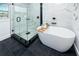 Elegant bathroom featuring a modern soaking tub, glass shower, and sleek black fixtures on dark flooring at 1873 Murray Ave, Clearwater, FL 33755