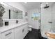 Updated bathroom with black tile flooring, white vanity, sleek fixtures, and a glass-enclosed shower at 1873 Murray Ave, Clearwater, FL 33755