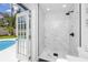 Modern bathroom adjacent to pool with glass shower, sleek fixtures, and direct outdoor access at 1873 Murray Ave, Clearwater, FL 33755