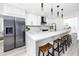Bright kitchen with quartz countertops, stainless steel refrigerator, and eat-in breakfast bar at 1873 Murray Ave, Clearwater, FL 33755