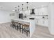 Spacious kitchen with a large quartz island with barstool seating and modern pendant lighting at 1873 Murray Ave, Clearwater, FL 33755