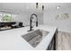 Kitchen island with a stainless steel sink and black faucet, quartz countertop and modern cabinets at 1873 Murray Ave, Clearwater, FL 33755