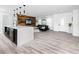 Open-concept living area with modern kitchen island, wood accent wall, and hardwood-style floors at 1873 Murray Ave, Clearwater, FL 33755