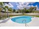 Backyard pool featuring patio seating, fully fenced yard, and tropical landscaping at 1873 Murray Ave, Clearwater, FL 33755