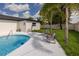 A backyard pool with patio seating and palm trees creates a relaxing outdoor oasis at 1873 Murray Ave, Clearwater, FL 33755