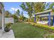 Lush backyard with a modern jacuzzi under a covered patio, vibrant plants, and well-manicured lawn at 213 N Hesperides St, Tampa, FL 33609