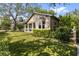 Landscaped front yard of lovely home with covered porch, bay window, and green lawn at 213 N Hesperides St, Tampa, FL 33609