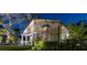 Charming exterior view of the home with a quaint porch, bay window, and lush landscaping at 213 N Hesperides St, Tampa, FL 33609