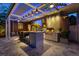 This gourmet outdoor kitchen with marble countertops has a grill and bar seating under a covered and lit patio at 213 N Hesperides St, Tampa, FL 33609