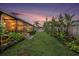 Serene backyard featuring a lush lawn, tropical landscaping, and a screened-in patio for relaxing outdoors at 2134 Serpentine S Cir, St Petersburg, FL 33712