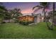 Backyard with lush green grass, tropical landscaping and screened-in patio perfect for enjoying evenings outside at 2134 Serpentine S Cir, St Petersburg, FL 33712