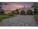 Beautiful home featuring a brick driveway, lush landscaping, and a two-car garage with arched doors at 2134 Serpentine S Cir, St Petersburg, FL 33712