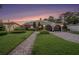 Charming home with manicured lawn, brick pathway, lush landscaping, and a two-car garage with arched doors at 2134 Serpentine S Cir, St Petersburg, FL 33712