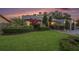 Well-maintained front yard with lush green grass, mature landscaping, and a paved driveway leading to the garage at 2134 Serpentine S Cir, St Petersburg, FL 33712
