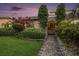 Well-manicured yard with mature landscaping and hardscape leading to the home's entrance at 2134 Serpentine S Cir, St Petersburg, FL 33712