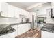 Modern kitchen featuring white cabinets, granite countertops, and stainless steel appliances at 2134 Serpentine S Cir, St Petersburg, FL 33712