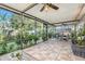 Enclosed patio area featuring an outdoor dining area, tile flooring, and lush foliage at 2134 Serpentine S Cir, St Petersburg, FL 33712
