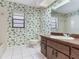 Bathroom with a single sink vanity, and toilet with leafy wallpaper, and a window for natural light at 2217 High Point Dr, Brandon, FL 33511