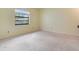 Bright bedroom with neutral carpet, large window, and light yellow walls at 2217 High Point Dr, Brandon, FL 33511