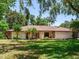 Ranch-style home featuring a well-manicured lawn, palm trees, and stone accents on the facade creating curb appeal at 2217 High Point Dr, Brandon, FL 33511