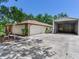 View of garage with white door and additional metal storage building at 2217 High Point Dr, Brandon, FL 33511