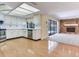 Bright kitchen features white cabinets, stainless steel appliances, and a view into the living room with stone fireplace at 2217 High Point Dr, Brandon, FL 33511