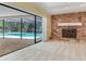 Living room with stone fireplace and a view of the pool through sliding glass doors at 2217 High Point Dr, Brandon, FL 33511
