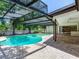 Screened-in pool with surrounding brick paver patio and access to the lanai and backyard, perfect for entertaining at 2217 High Point Dr, Brandon, FL 33511