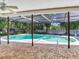 A screened in pool with a brick paver patio with great sun exposure with a fan on the covered porch at 2217 High Point Dr, Brandon, FL 33511